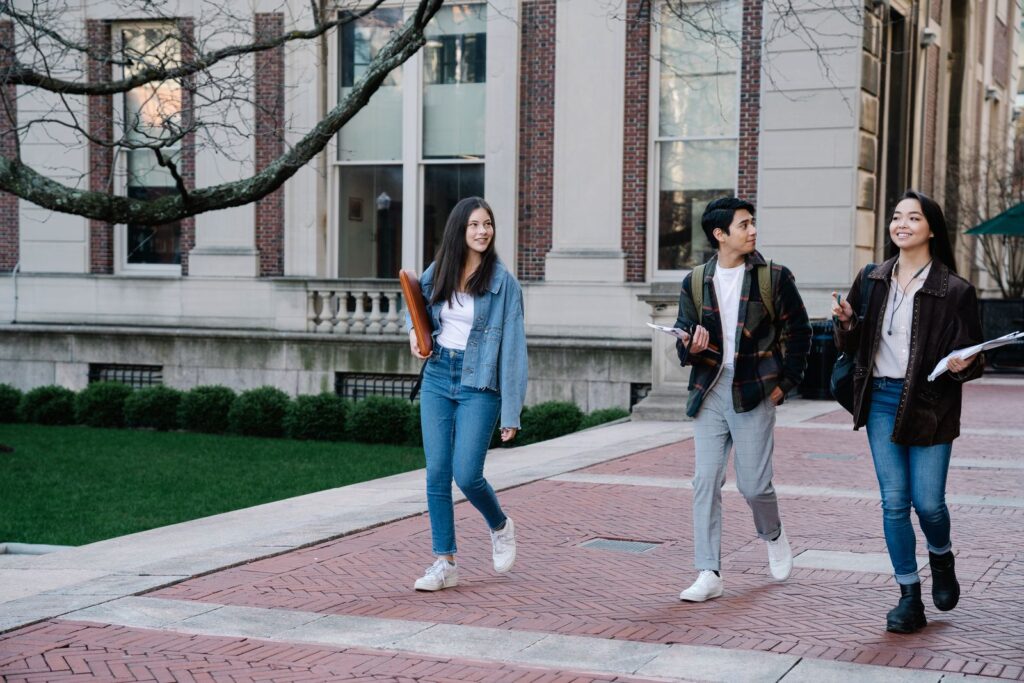 Students walking on a sunny university campus where a campus photo booth fits