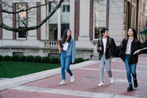 Students walking on a sunny university campus where a campus photo booth fits