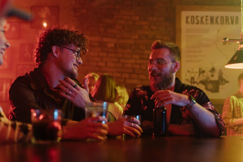 Friends laughing together at a busy South Florida bar, the kind of room where a free photo booth for business pays off