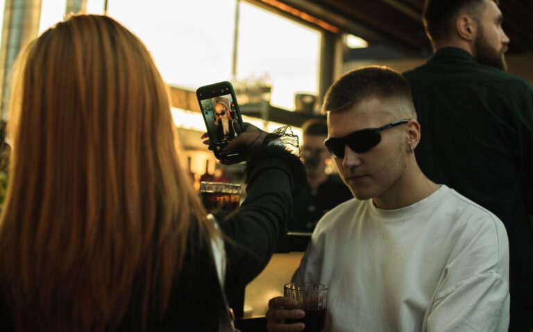 Friends taking selfies over drinks in a lively bar