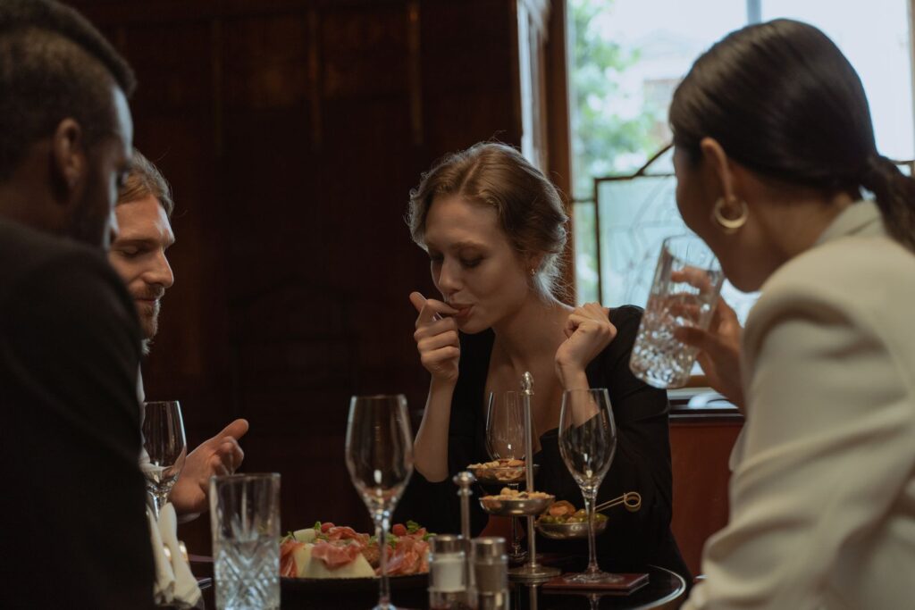 Friends sharing dinner and drinks at a stylish restaurant built to make your restaurant instagrammable