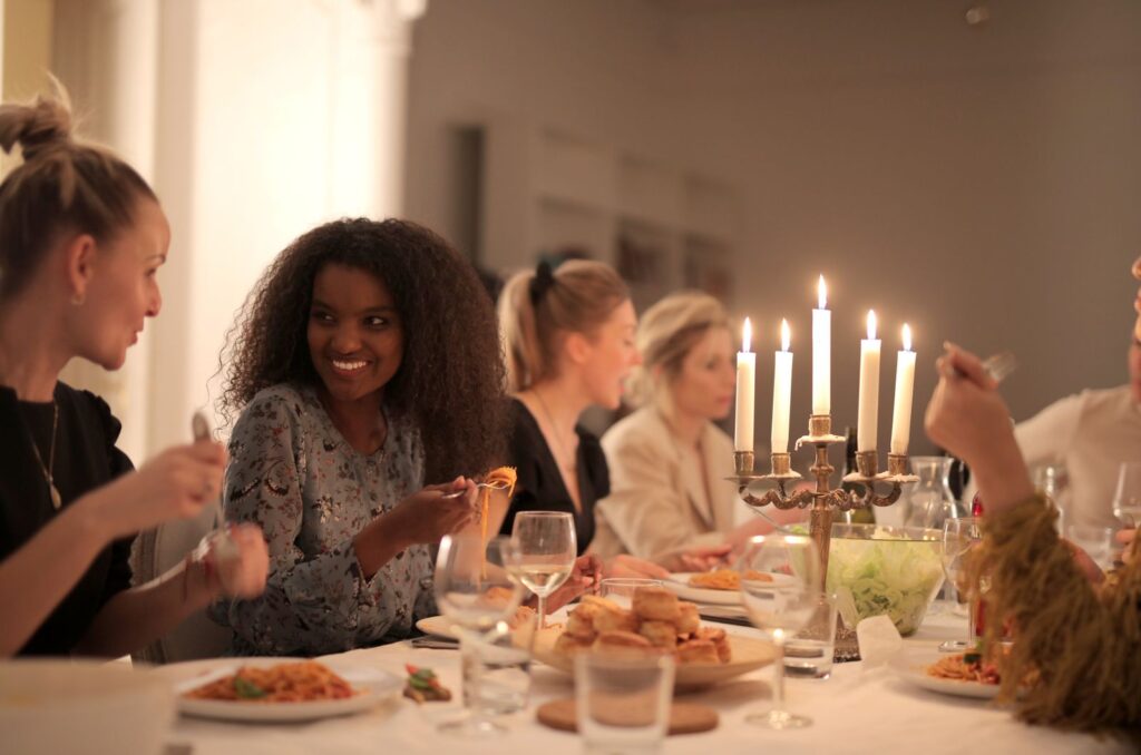 Friends sharing a candlelit dinner at a restaurant table