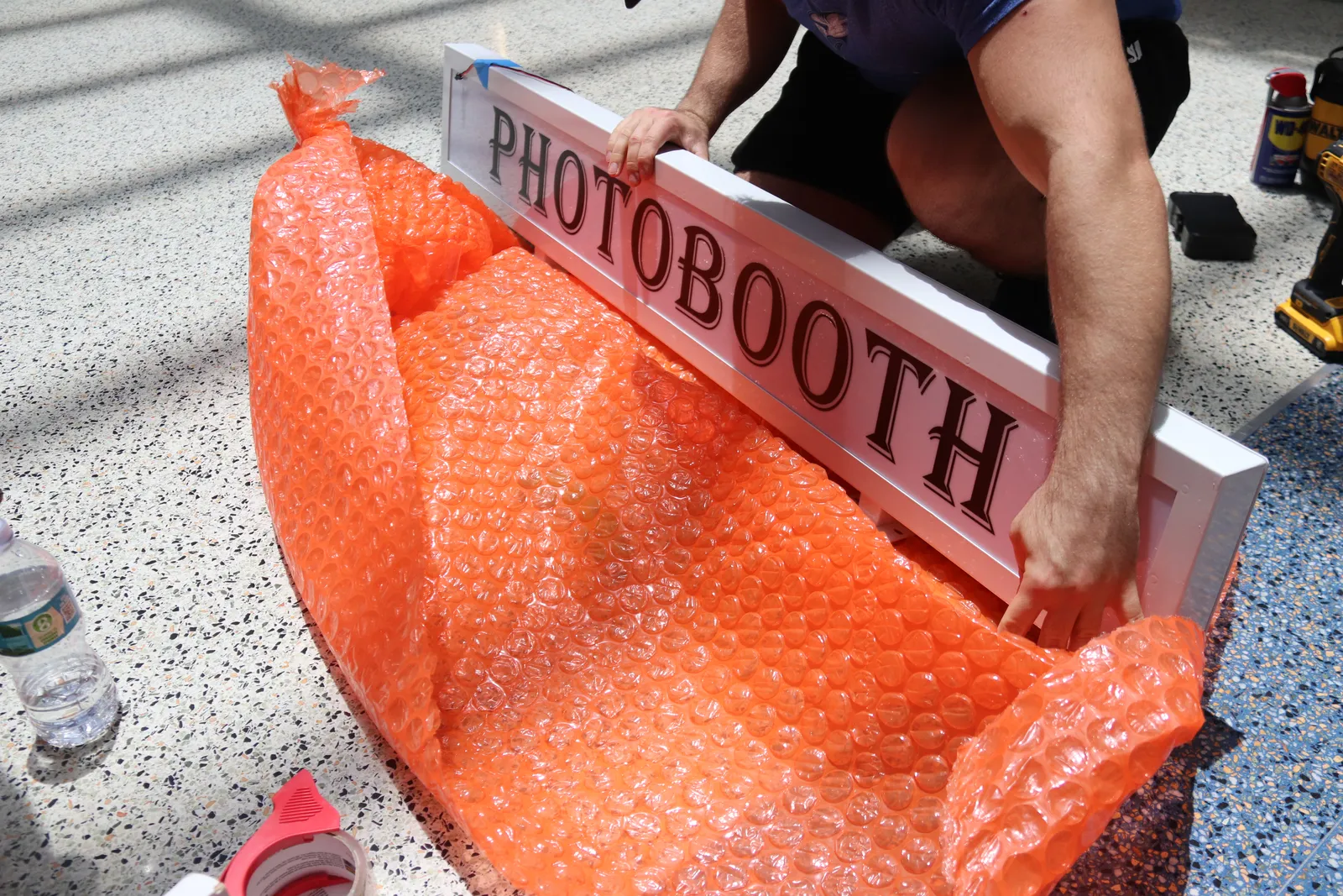 Unboxing the photo booth sign on install day
