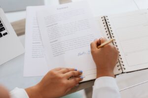 Hands signing a contract on a desk