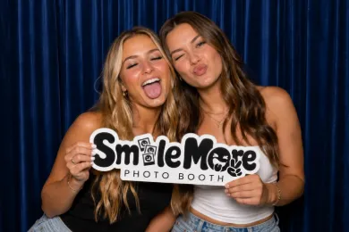 Friends holding a SmileMore sign