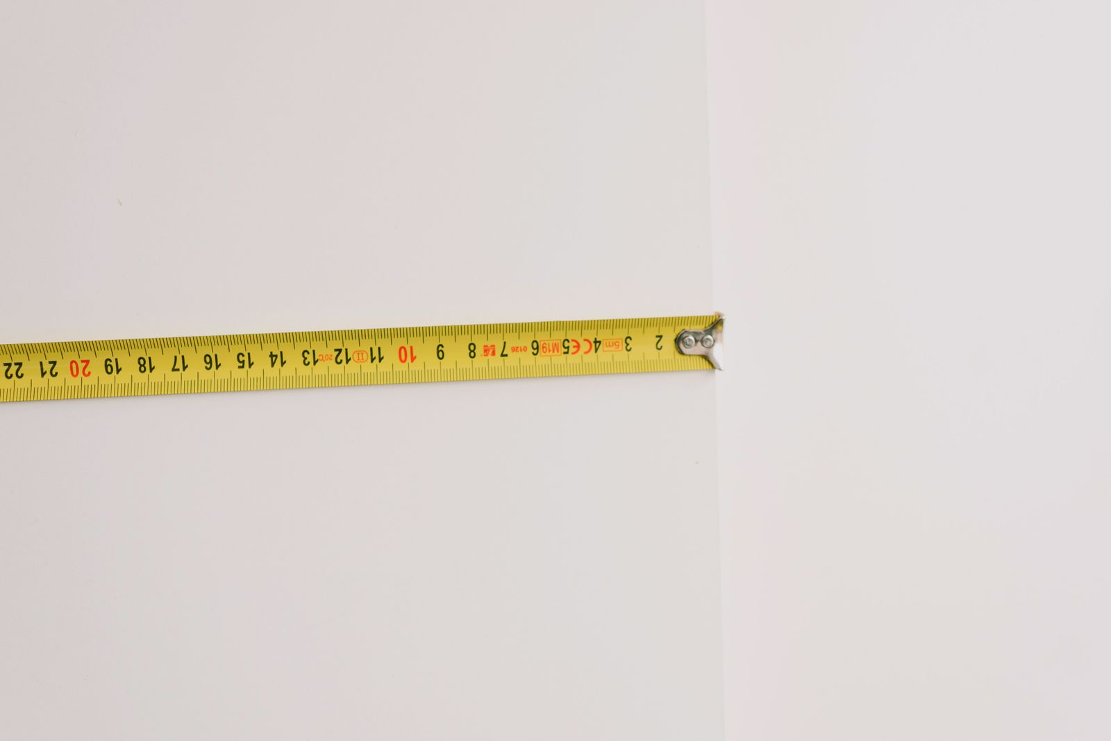 Yellow tape measure against a wall