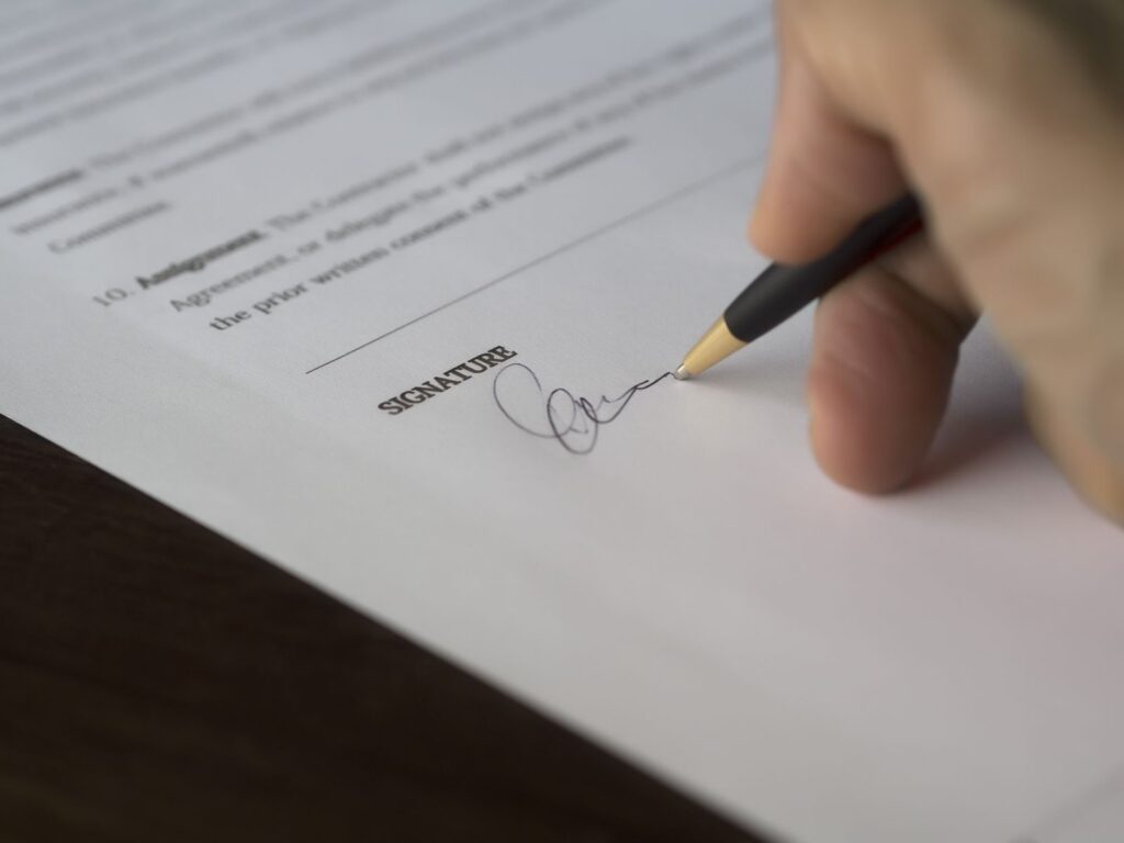 Hand signing a vending machine contract Florida venue owners should read first