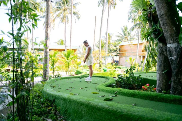 Woman playing mini golf on a tropical course