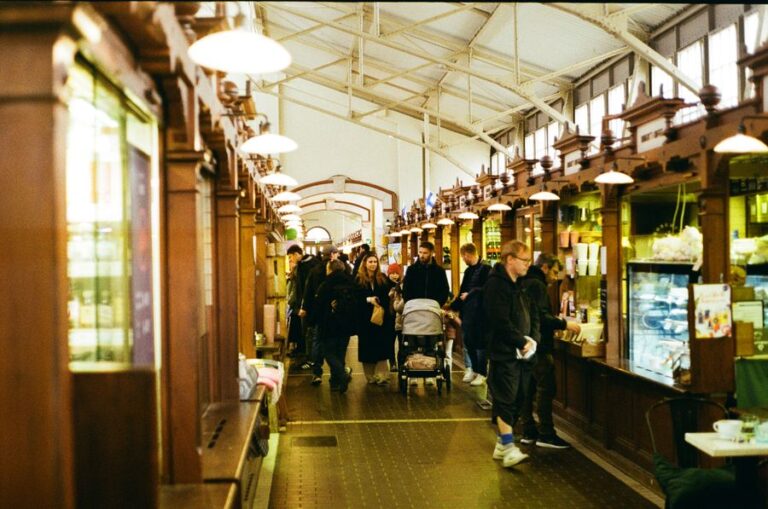 Busy indoor food hall with people browsing stalls